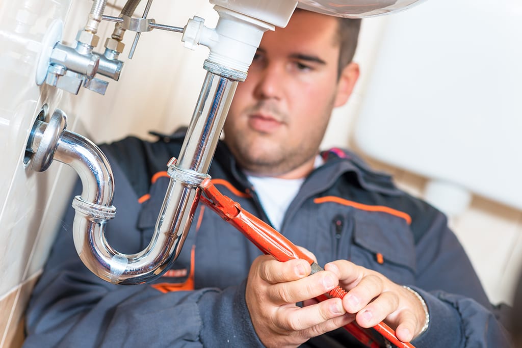 Messer's Plumbing repairing a pipe under sink